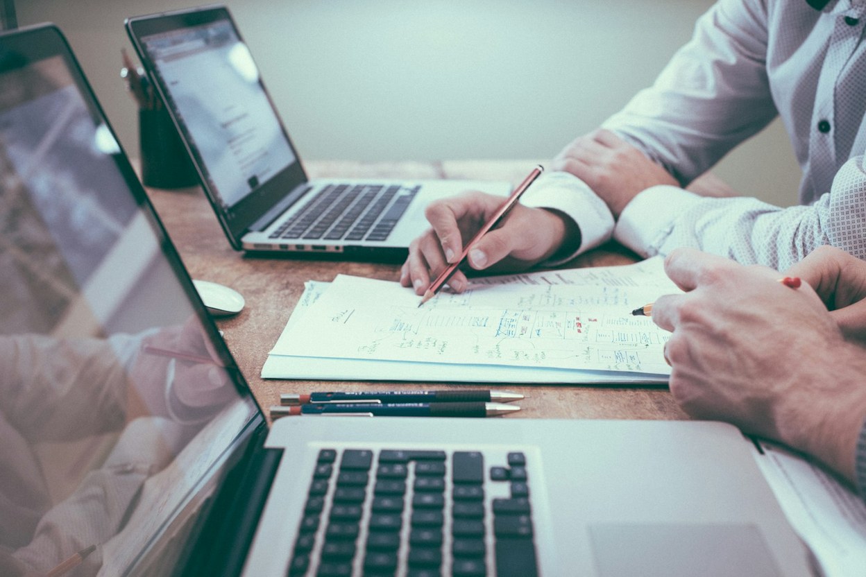 Laptop, notebook, and coffee on a desk — build your REAL ID document checklist.