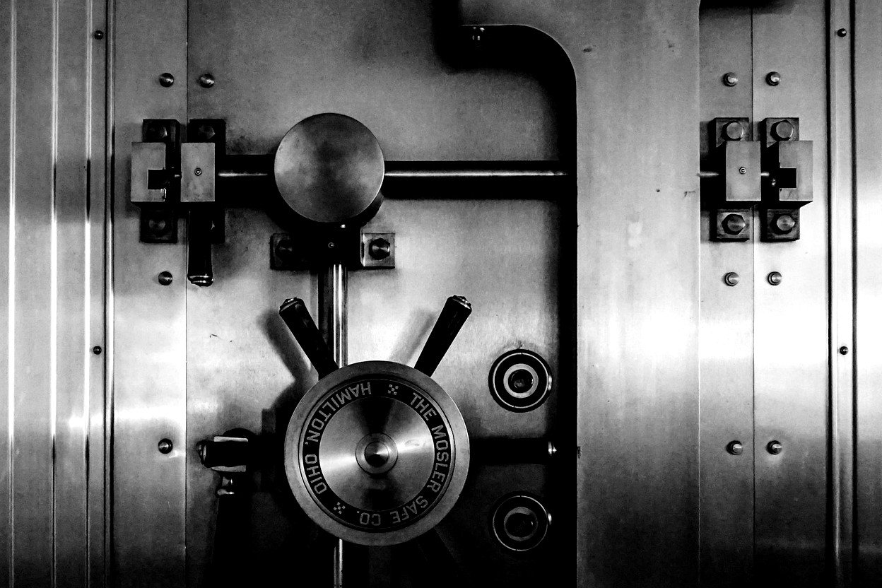 Close-up of a heavy vault door locking mechanism — when the paper trail needs a bond.